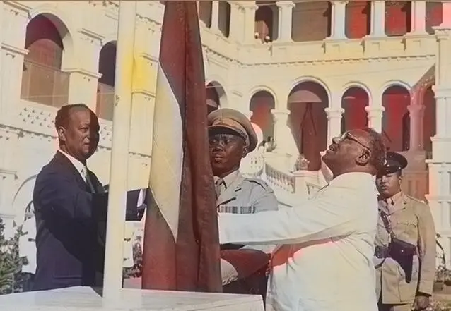 Prime Minister Ismail al-Azhari raises Sudan's flag, with opposition leader Mohamed Ahmed Mahgoub beside him